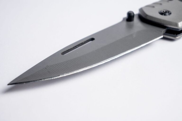 Macro close-up of a pocket knife blade tip showing grind lines