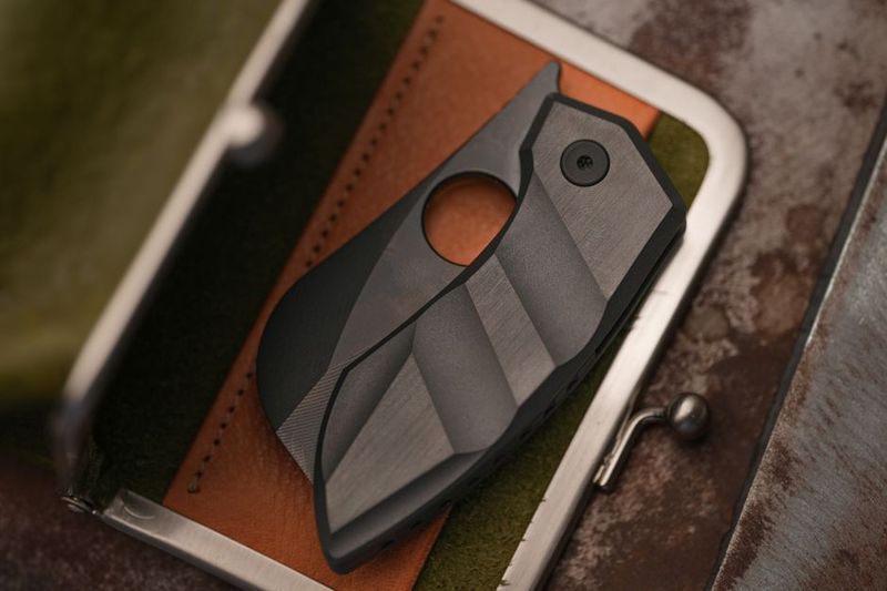 Compact EDC folding knife on leather wallet, daily carry fit