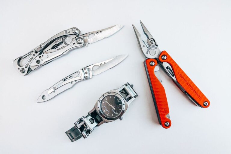 Flat lay of several EDC multitools and a watch for comparison
