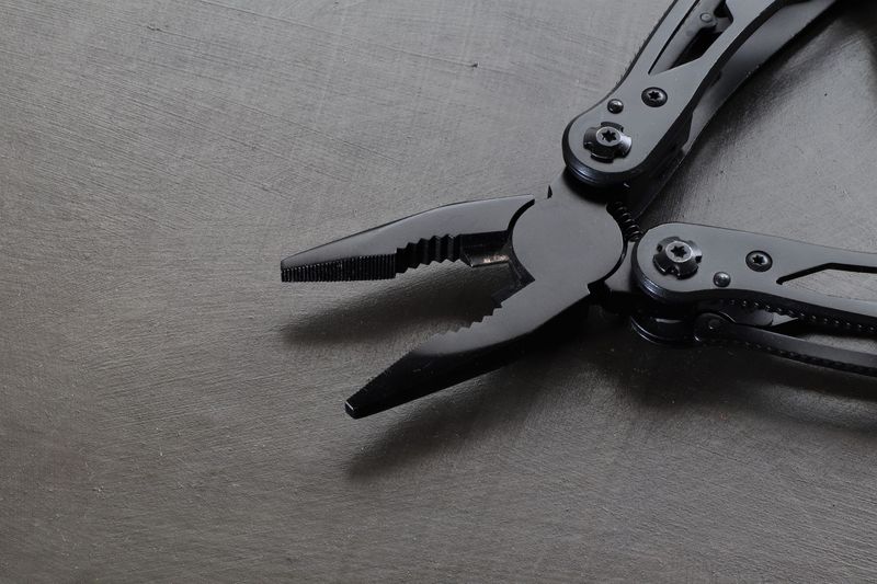 Macro shot of a flagship black EDC multitool's pliers mechanism