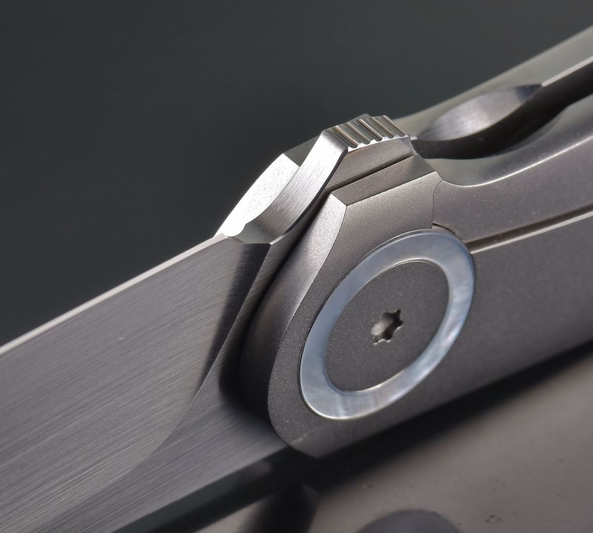Macro close-up of a pocket knife's pivot and blade detent mechanism