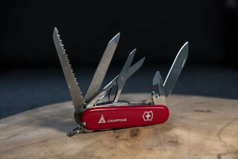 Red Victorinox Swiss Army knife opened showing multiple blades and tools