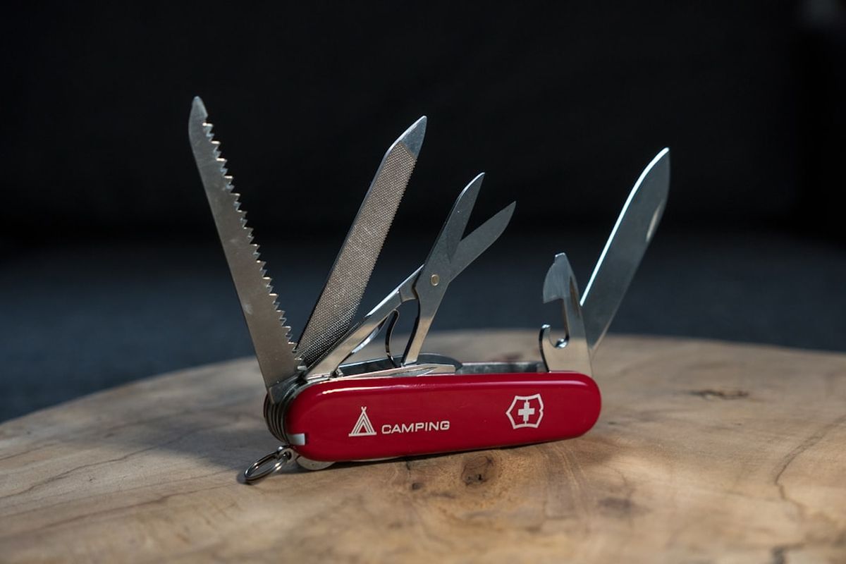Red Victorinox Swiss Army knife opened showing multiple blades and tools