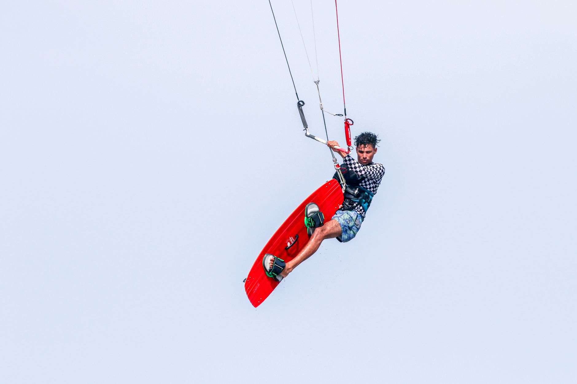 A kiteboarder skillfully navigates midair in an exciting water sport adventure.