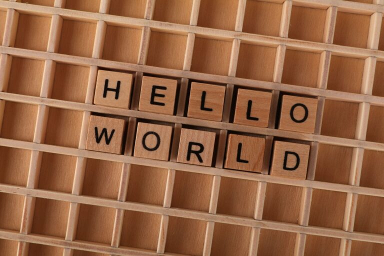 Wooden blocks with letters spelling HELLO WORLD on a wooden grid background, ideal for language conc