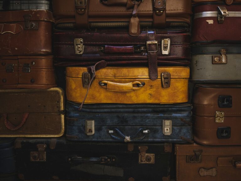 Vintage suitcases stacked in a rustic setting, showcasing classic travel charm.