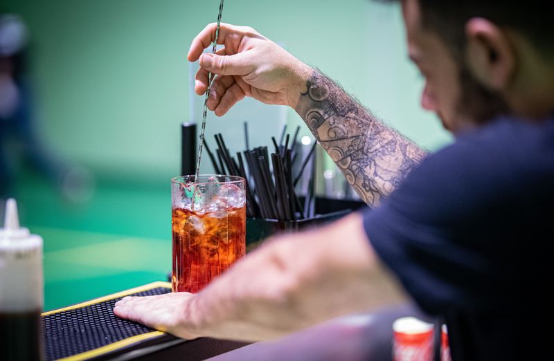bartender mixing a cocktail during a night shift, bartender EDC in use