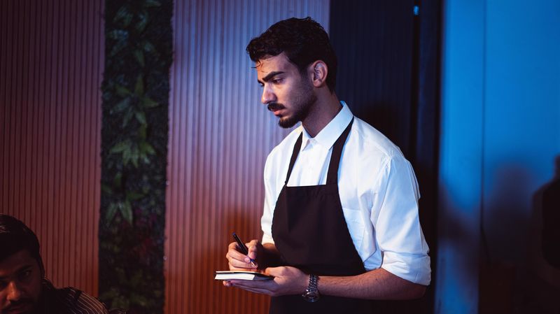 bartender writing down a drink order in a notebook