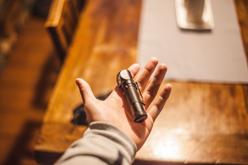 small pocket flashlight held in hand, used by bartenders for checking IDs