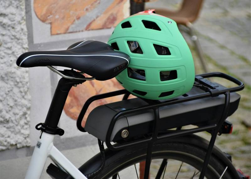 A helmet clipped to a bike rack as part of a commuter EDC visibility setup