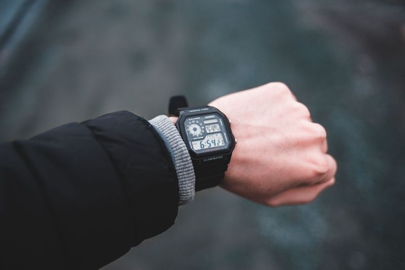 man checking durable EDC watch on wrist while commuting