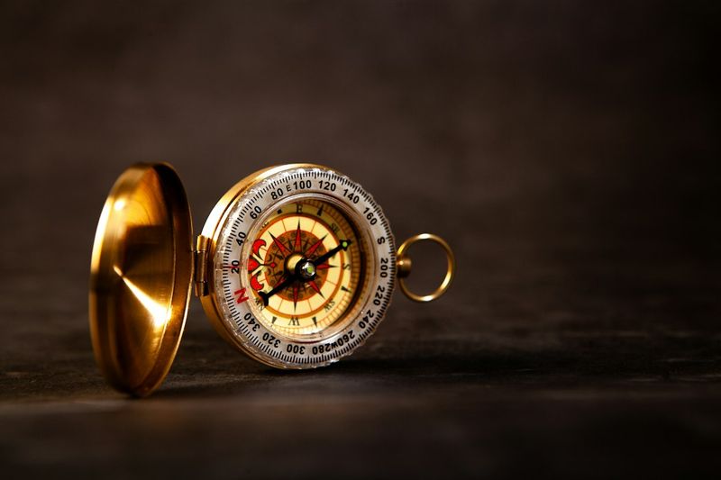 a closeup of a compass on a black background