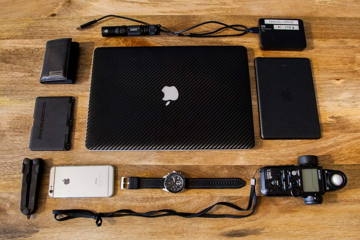 Delivery driver EDC gear flat lay on light wood desk