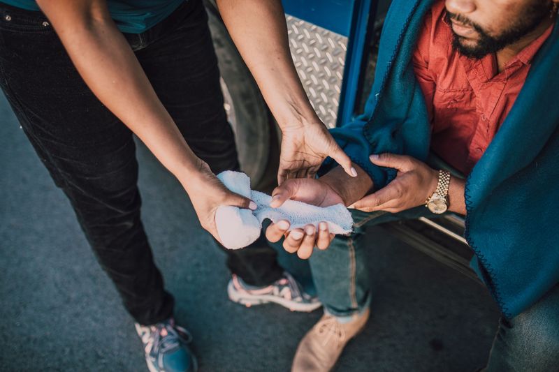 Wrapping a hand injury with gauze from a pocket first aid kit