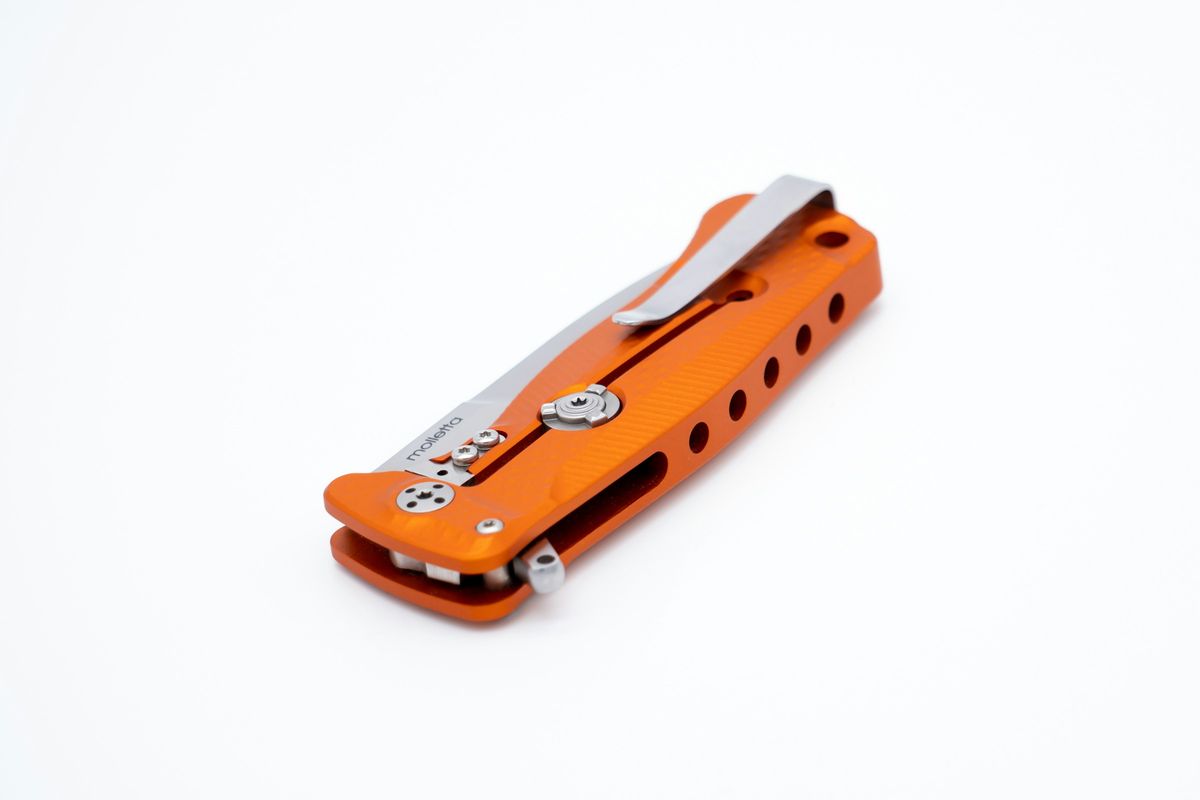 Closed liner lock EDC pocket knife with orange G10 handle and pocket clip