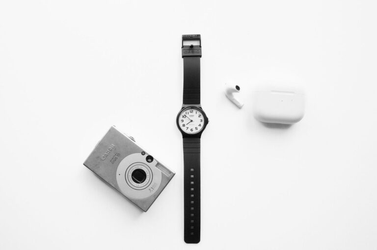 EDC watches under $200 minimalist flatlay with camera and earbuds