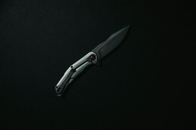Black liner lock folding knife deployed showing the blade locked open