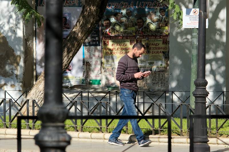 man checking phone on city street during daily carry with low battery
