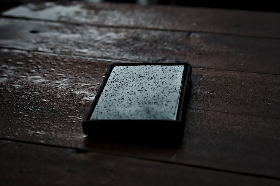 A detailed close-up of a smartphone from side, focusing on the smooth side profile and power button. The shallow depth of fie