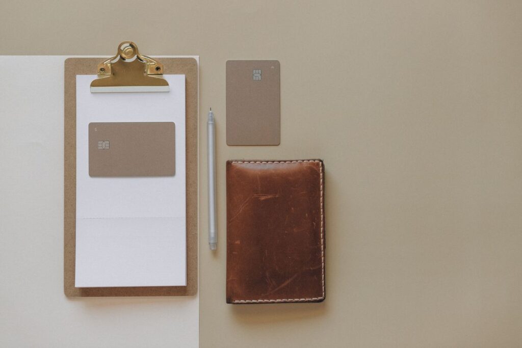 Realtor EDC essentials laid out on a desk with a pen, wallet, and clipboard