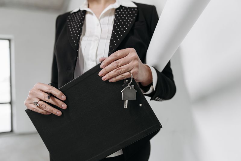 Realtor holding a keychain and clipboard before a showing, real estate agent EDC