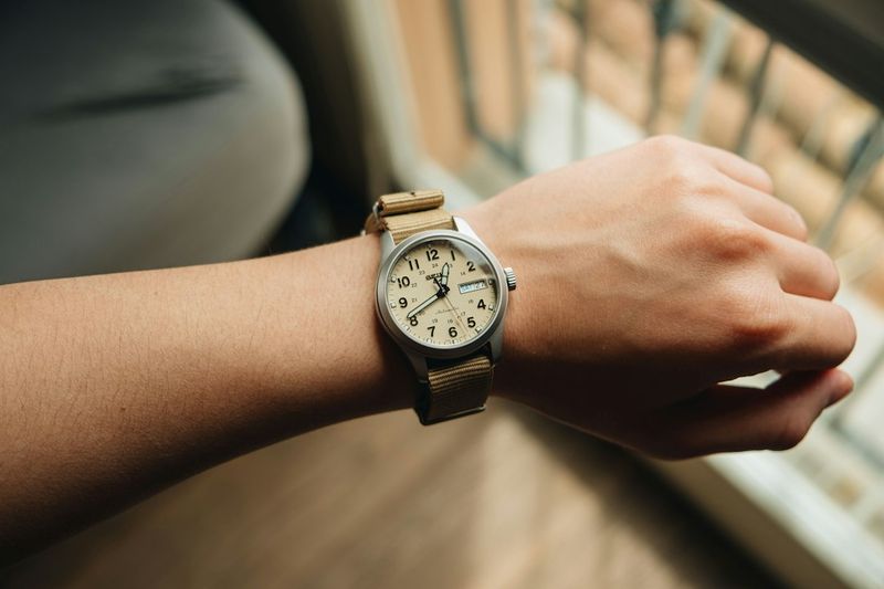 Analog wristwatch on a teacher's wrist while writing notes for a school day