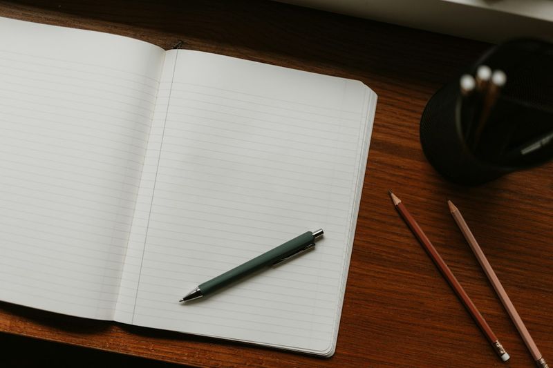Teacher's everyday carry items including pen, notebook, and wallet laid out on a desk
