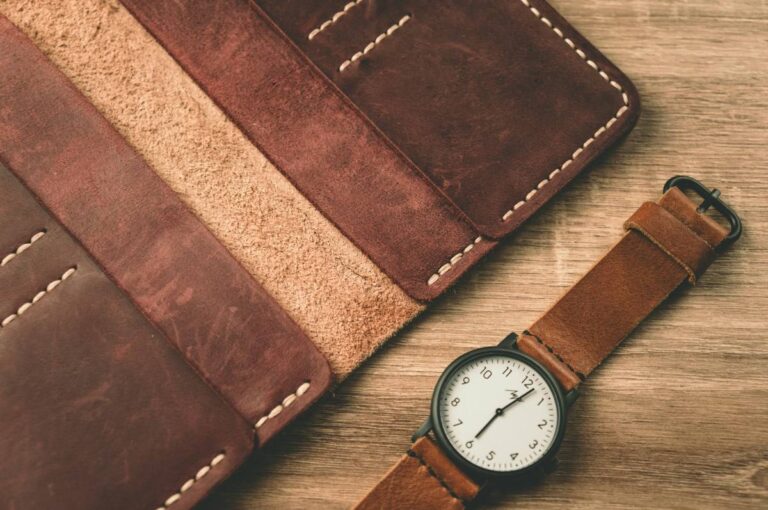 Traveler EDC kit with travel wallet and watch on a wood desk