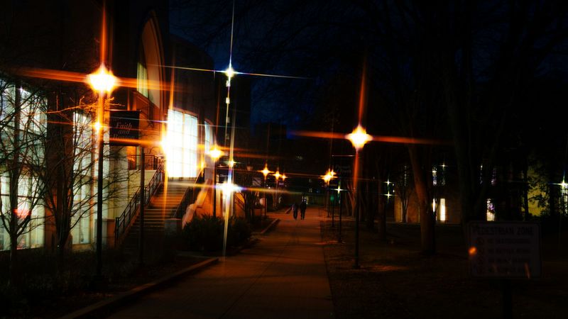 Student walking campus at night with EDC safety light