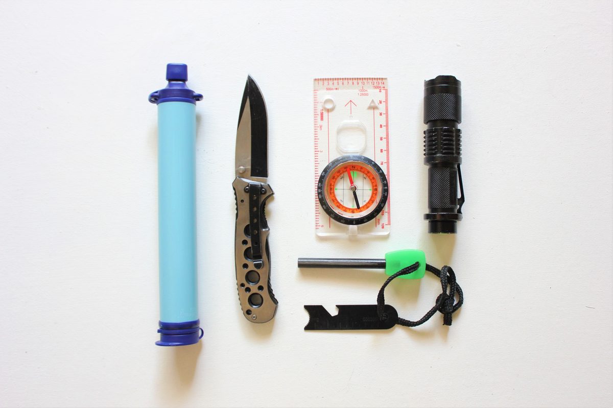 winter edc gear flat lay with knife flashlight and compass